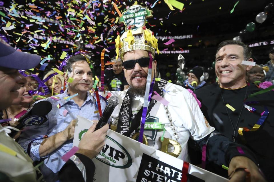 Bob "Notorious B.O.B." Shoudt celebrates after winning the Wing Bowl on Friday, Feb. 3, 2017 in Philadelphia. The morning eating ordeal draws boozy spectators who tailgate beforehand outside the city's sports arena to watch flamboyant contestants and suggestively-clad women known as Wingettes. This year, rapper Coolio performed between rounds. (David Swanson/The Philadelphia Inquirer via AP)