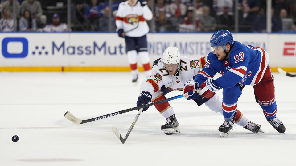 New York Rangers defenseman Adam Fox (23) passes the puck against Florida Panthers center Eetu Luostarinen (27) during the third period of Game 1 of the NHL hockey Eastern Conference Stanley Cup playoff finals, Wednesday, May 22, 2024, in New York. (AP Photo/Julia Nikhinson)