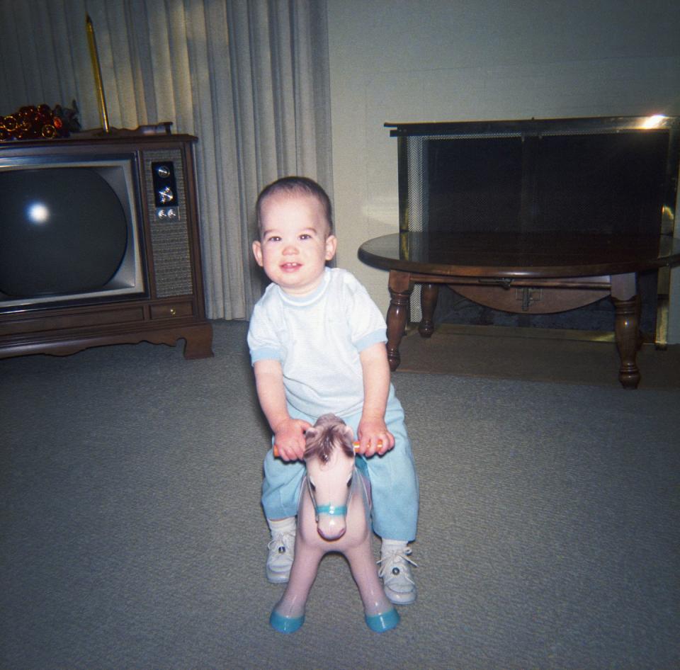 baby boy on toy horse in living room