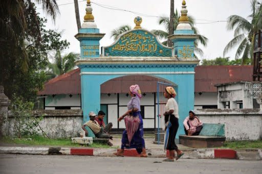 Muslim women walk past a mosque in Sittwe, capital of Myanmar's western Rakhine state, on June 6, 2012. Despite generations as part of the religious fabric of the country Muslims are considered foreigners in Buddhist-majority Myanmar, where tensions spilled into deadly violence this week