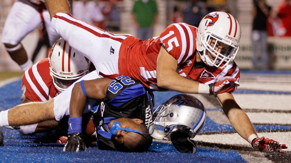 Middle Tennessee running back William Pratcher (29) loses his helmet as he is tackled in the end zone for a safety by Western Kentucky defenders Ryan Beard (15) and Andrew Jackson in the third quarter of an NCAA college football game on Thursday, Oct. 6, 2011, in Murfreesboro, Tenn. (AP Photo/Mark Humphrey)