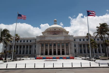 FILE PHOTO: The flags of the U.S. and Puerto Rico fly outside the Capitol building in San Juan