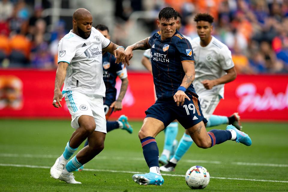 FC Cincinnati forward Brandon Vázquez (19) shoots as New England Revolution defender Andrew Farrell (2) defends in the first half of the MLS match between FC Cincinnati and New England Revolution at TQL Stadium in Cincinnati on Saturday, May 21, 2022. 