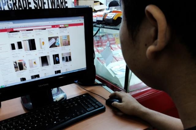 A man looks at an online store for Apple's iPhone 7 in Jakarta