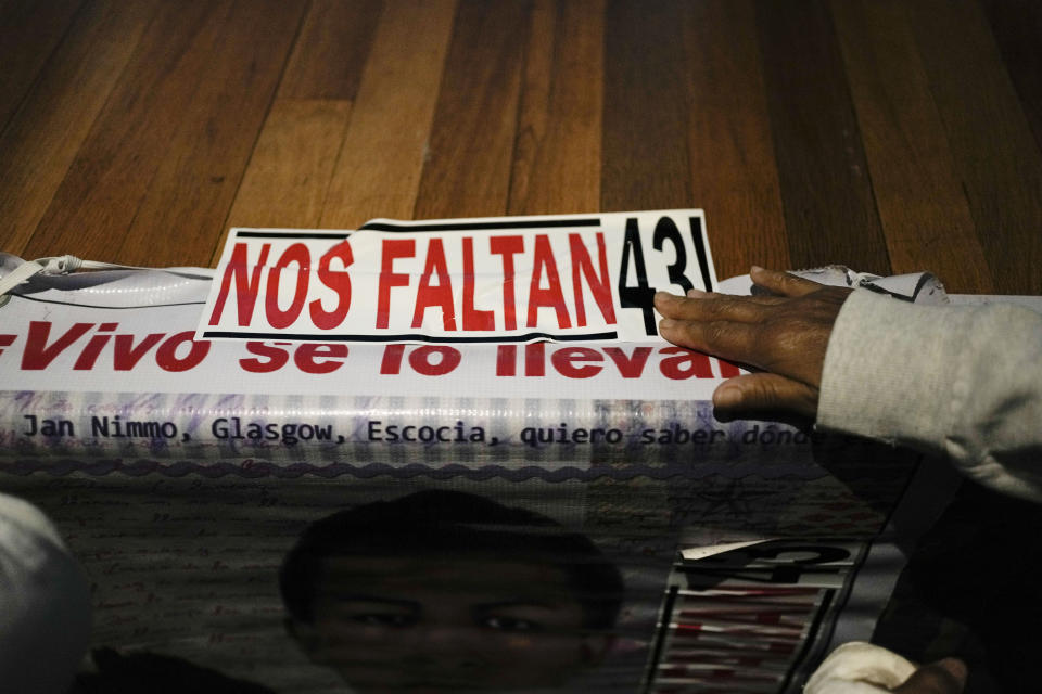 A family member of the 43 missing students from Ayotzinapa, post a sign referring to the 43 missing students from Ayotzinapa, during a presentation of a report by the Interdisciplinary Group of Independent Experts (GIEI), in Mexico City, Tuesday, July 25, 2023. The GIEI presented its sixth report on the case of the missing students who disappeared on Sept. 26, 2014. (AP Photo/Eduardo Verdugo)