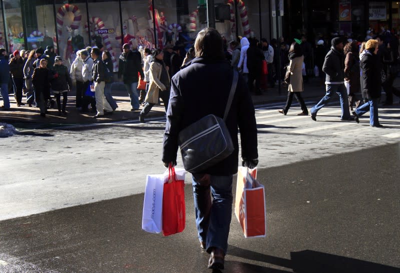 A holiday shopper carries bags through Herald Square in New York