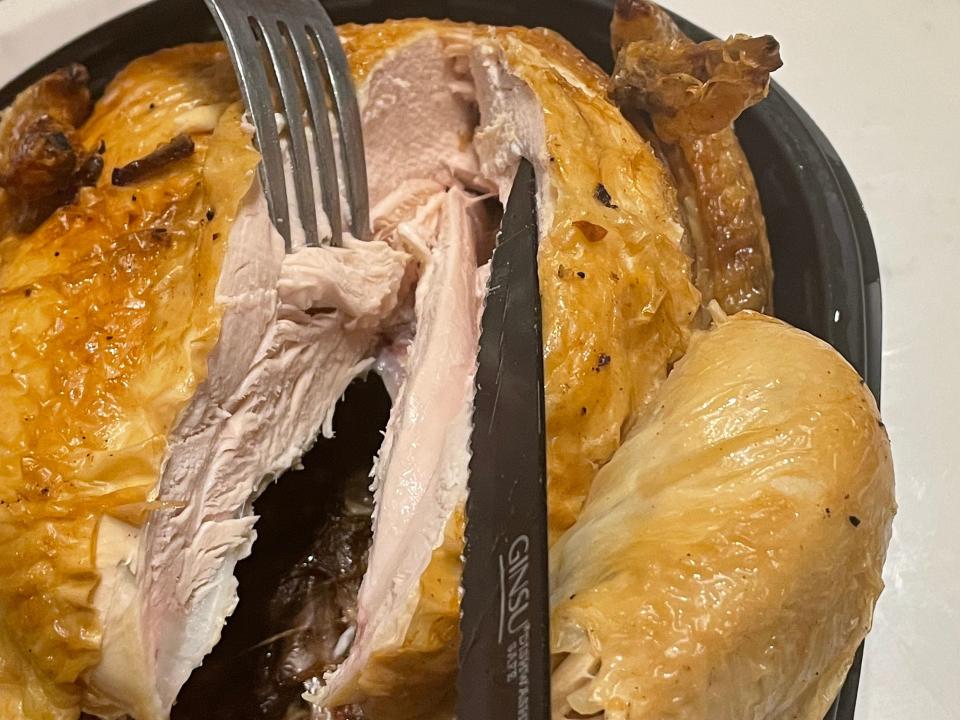 The writer cuts into the breast meat of Kroger rotisserie chicken