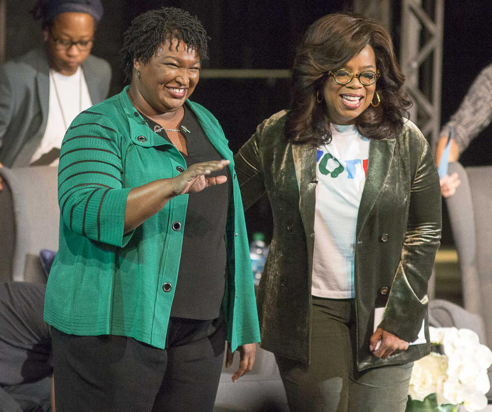 Oprah Winfrey, right, and Georgia gubernatorial candidate Stacey Abrams greet a crowd gathered for a town hall conversation at the Cobb Civic Center's Jennie T. Anderson Theatre in Marietta, GA., Thursday, November 1, 2018. Winfrey visited Georgia on Thursday to canvass neighborhoods in Metro Atlanta and show her support for gubernatorial candidate Stacey Abrams. (Alyssa Pointer/Atlanta Journal-Constitution via AP)