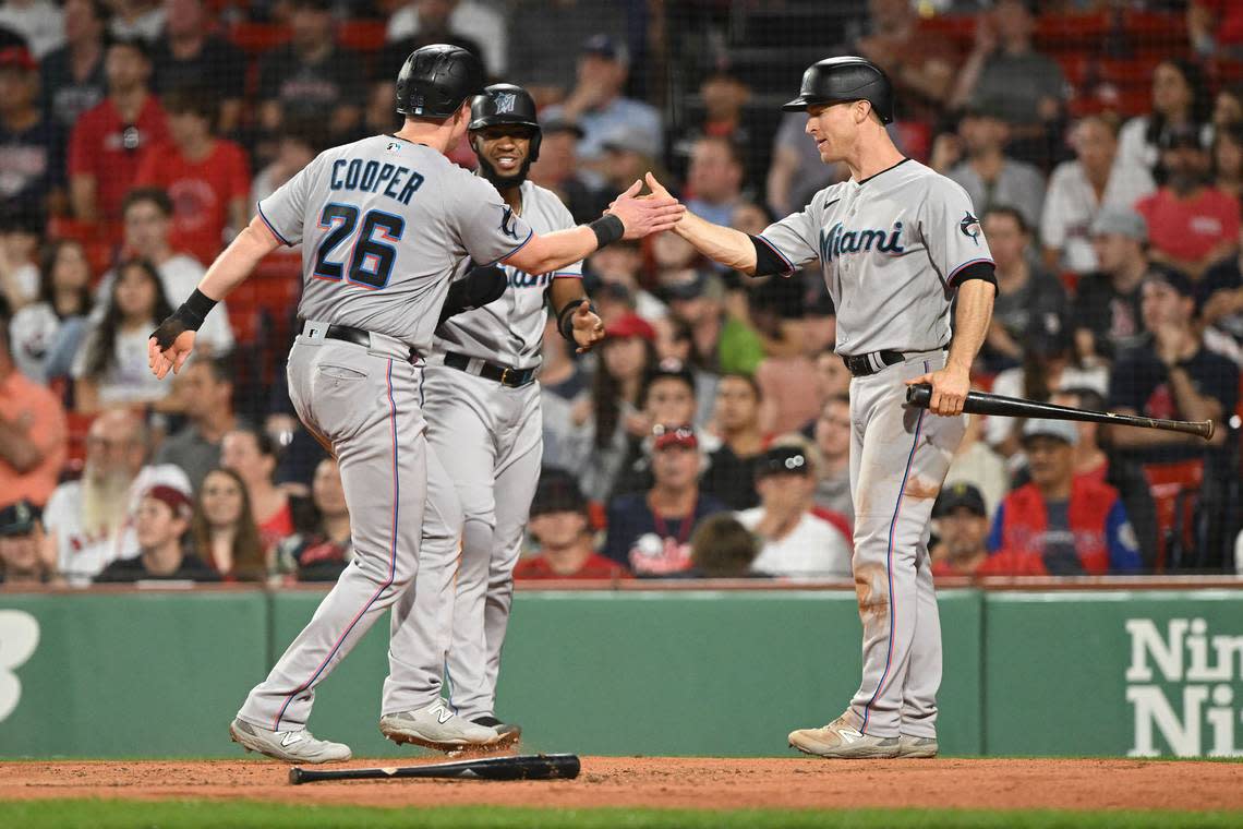 Miami Marlins first baseman Garrett Cooper (26) high-fives Miami Marlins shortstop Joey Wendle (18) after scoring a run against the Boston Red Sox during the sixth inning at Fenway Park.