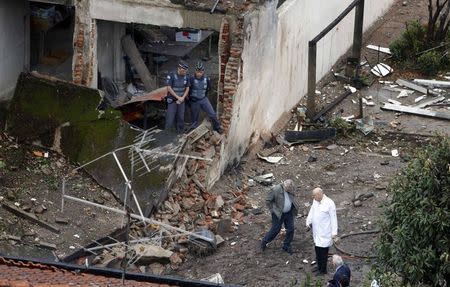 Rescue personnel survey the wreckage site of the crashed private jet which was carrying candidate Eduardo Campos, who was running third in polls ahead of Brazil's October presidential election, in Santos August 13, 2014. REUTERS/Paulo Whitaker