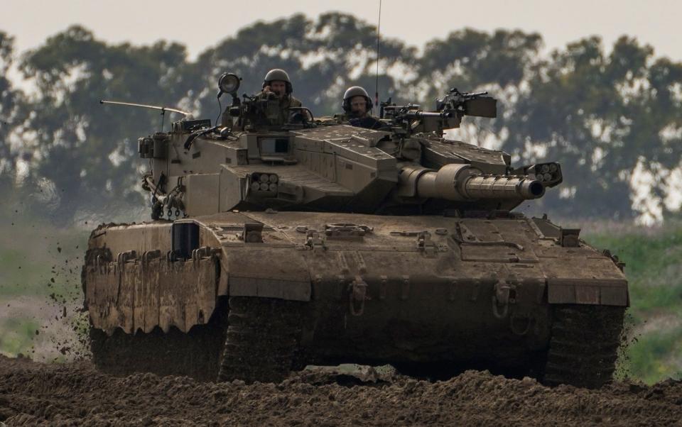 Israeli soldiers drive a tanks near the Gaza Strip border