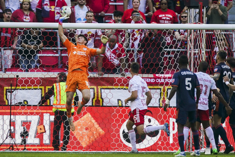 FC Cincinnati Goalkeeper Roman Celentano, Left, tips the ball over the goal after a kick by the New York Red Bulls during the first half of an MLS playoff soccer match, Saturday, Oct. 15, 2022, in Harrison, N.J. (AP Photo/Eduardo Munoz Alvarez)