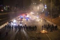 Israeli police disperse demonstrators blocking a highway during a protest against plans by Prime Minister Benjamin Netanyahu's government to overhaul the judicial system in Tel Aviv, Israel, Monday, March 27, 2023. Tens of thousands of Israelis have poured into the streets across the country in a spontaneous outburst of anger after Prime Minister Benjamin Netanyahu abruptly fired his defense minister for challenging the Israeli leader's judicial overhaul plan. (AP Photo/Oren Ziv)