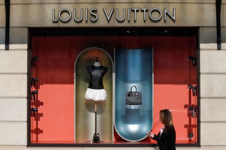 A woman walks past a Louis Vuitton shop in Brussels, Belgium March 10, 2016. REUTERS/Yves Herman/File Photo