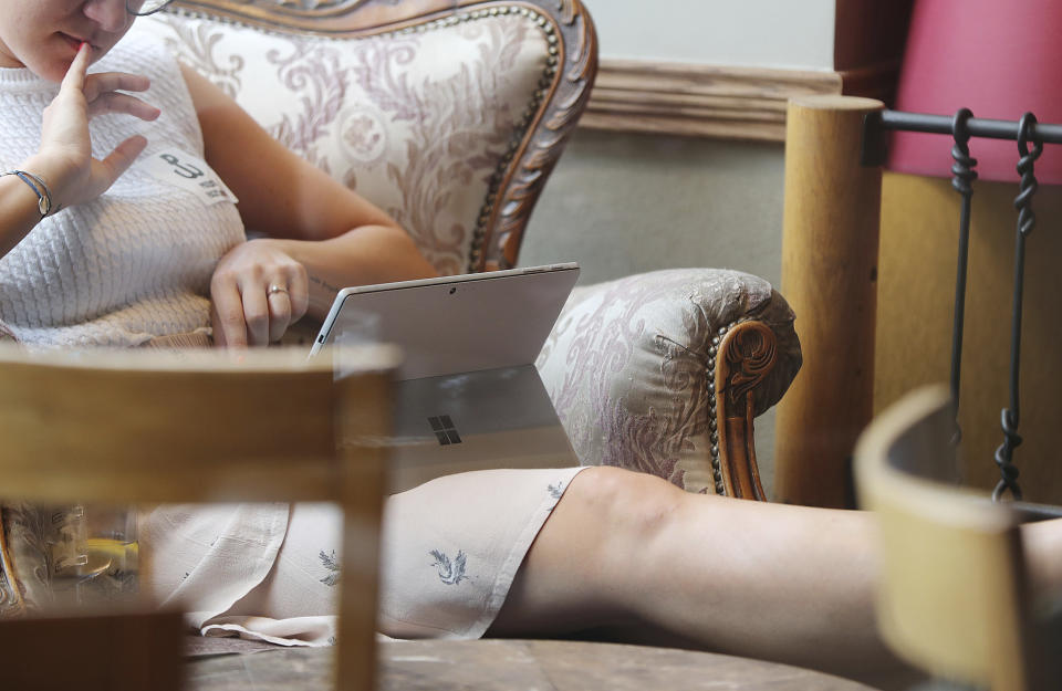 A young Polish woman works on her laptop in a cafe in Warsaw, Poland, Thursday, Aug. 1, 2019. Poland on Thursday scrapped its personal income tax for young employees earning less than dollars 22,000 a year, as part of a drive to reverse a brain drain and demographic decline that's dimming the prospects of a country that is otherwise experiencing strong economic growth.(AP Photo/Czarek Sokolowski)