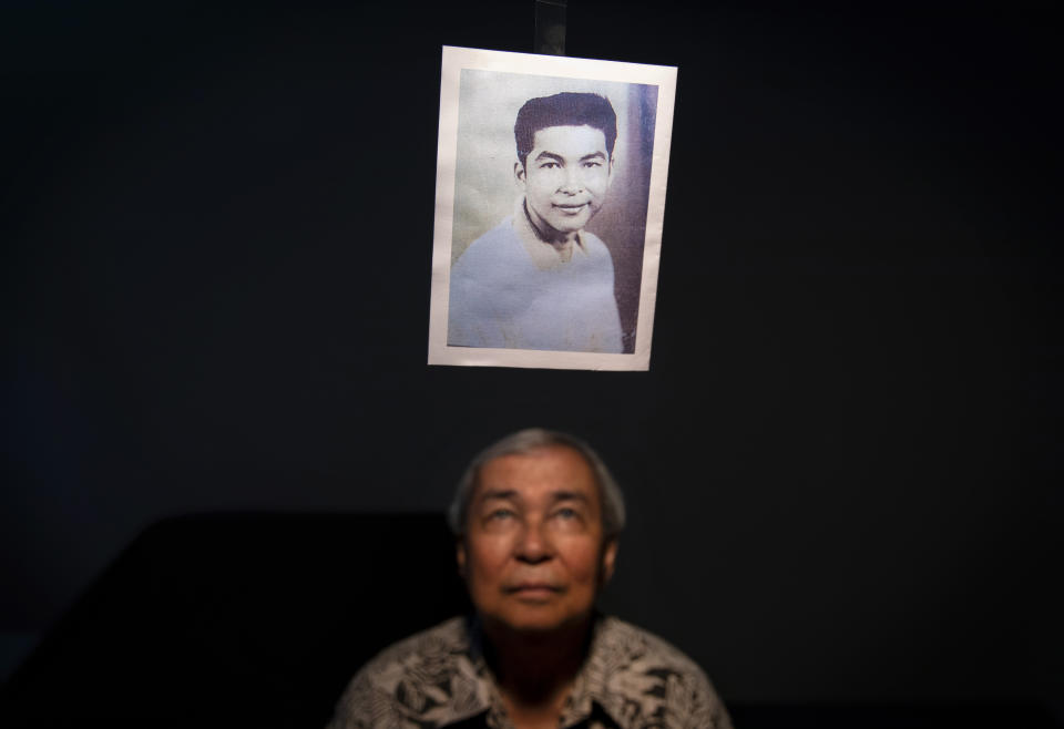 Leo Tudela, 75, looks up at a photo of himself when he was 13 years old, the age when he says in a lawsuit he was sexually abused by Brother Mariano Laniyo while living in a monastery and later by Louis Brouillard, a Catholic priest and scoutmaster for the Boy Scouts of America, in Hagatna, Guam, Monday, May 13, 2019. "We're all human beings so there is always forgiveness but this person, I don't think God will forgive him. I want to tell him right straight in his face, 'How could you do that to young boys? If that was your son would you do it?'" Laniyo and Brouillard are now dead. Brouillard acknowledged abuse allegations before he died. (AP Photo/David Goldman)