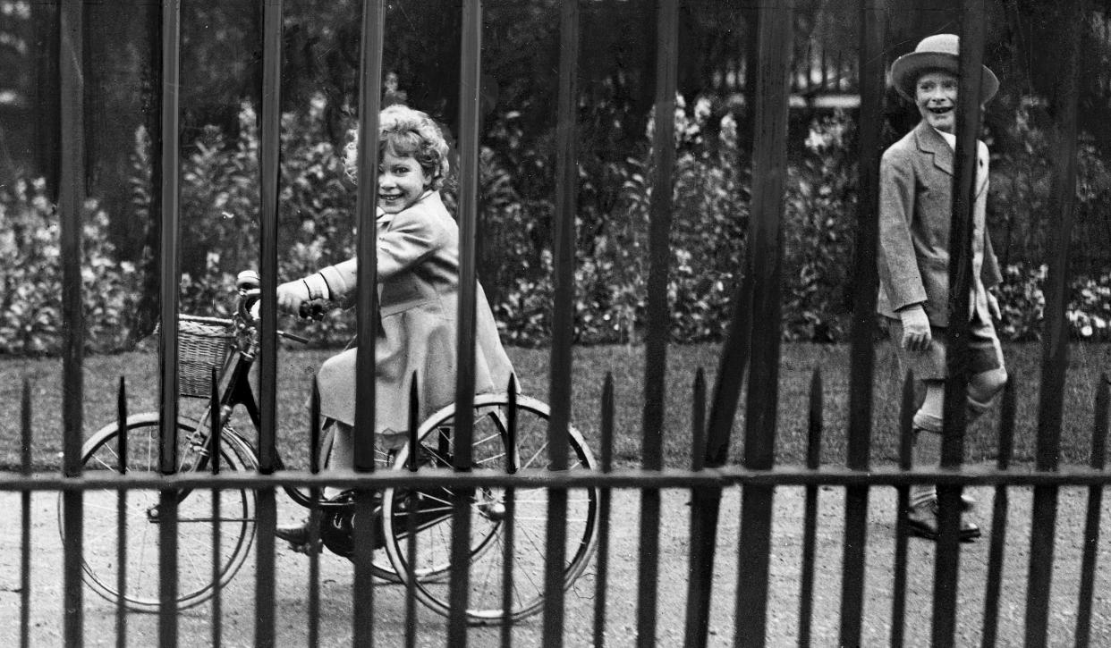 Britain's Princess Elizabeth, the little daughter of the Duke and Duchess of York, photographed on her tricycle in the gardens of her London Home on June 5, 1930, with her little cousin Gerald Lascelles, the youngest son of Princess Mary and Lord Harewood. 