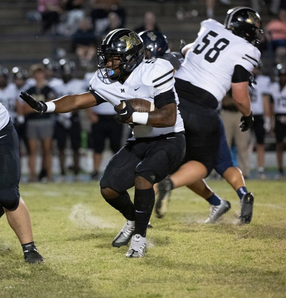 Milton's Tyree Haynes (No.5) finds a hole in the Gulf Breeze defense to pick up a few extra yards against the Dolphins during Friday night's gridiron action. 