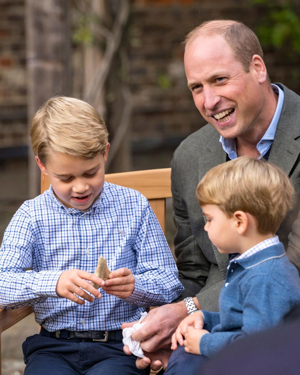 Prince George and Prince Louis with dad Prince William in the Kensington Palace gardens, examining an ancient giant shark tooth.