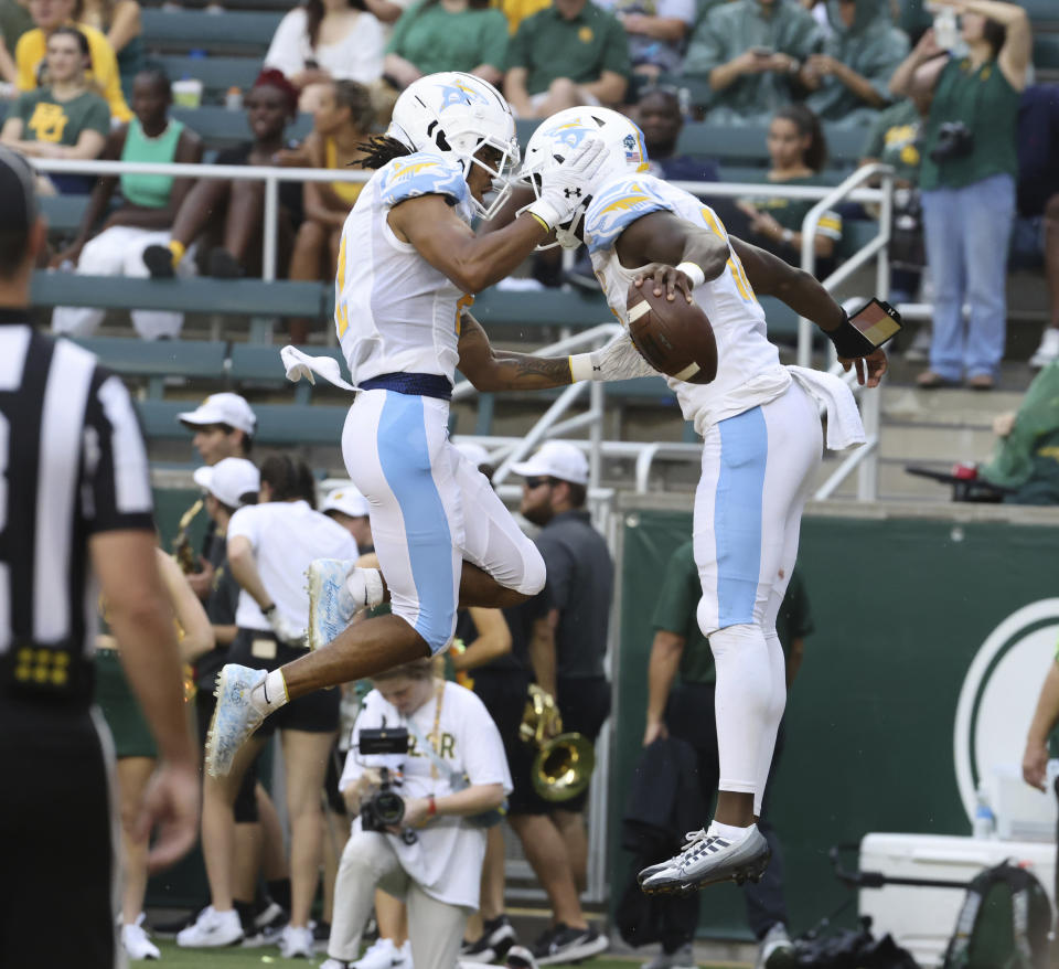 Long Island quarterback Chris Howell, right, celebrates with wide receiver Davon Wells after scoring against Baylor during the first half of an NCAA college football game, Saturday, Sept. 16, 2023, in Waco, Texas. (Rod Aydelotte/Waco Tribune-Herald via AP)