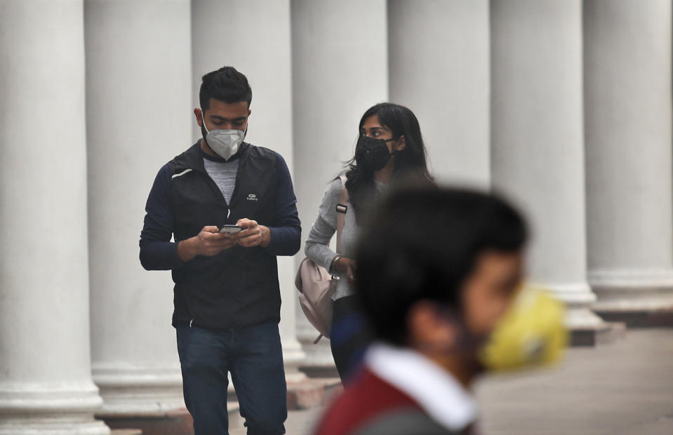 Indians walk wearing pollution masks in New Delhi, India, Thursday, Nov. 14, 2019. Schools in India's capital have been shut for Thursday and Friday after air quality plunged to a severe category for the third consecutive day, enveloping New Delhi in a thick gray haze of noxious air. (AP Photo/Manish Swarup)