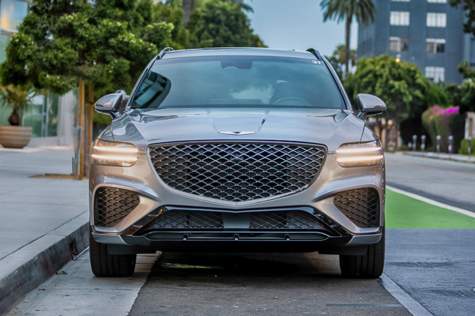 The front end of the Genesis GV70 SUV featuring a large grille and  cheetah-scratch headlights