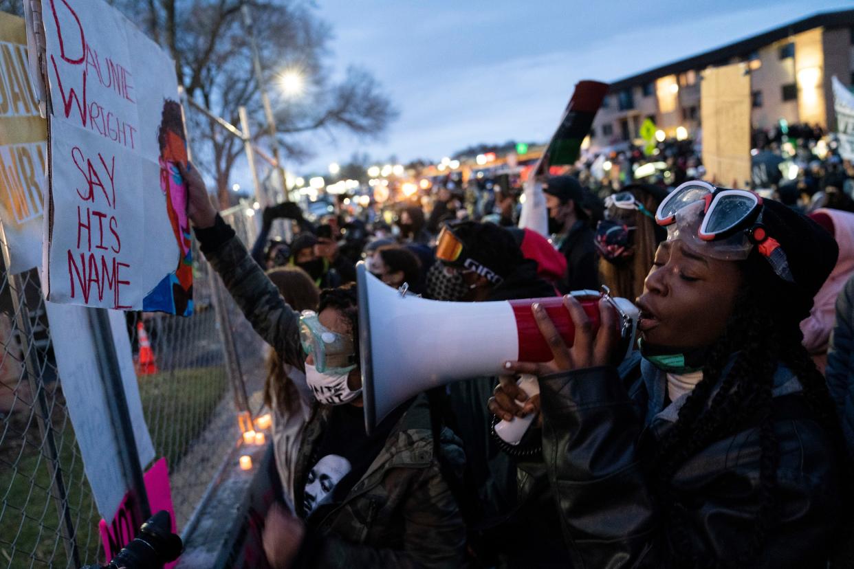 Demonstrators gather along a perimeter fence during a protest over Sunday's fatal shooting of Daunte Wright outside the Brooklyn Center Police Department on Wednesday, April 14, 2021, in Brooklyn Center, Minn.