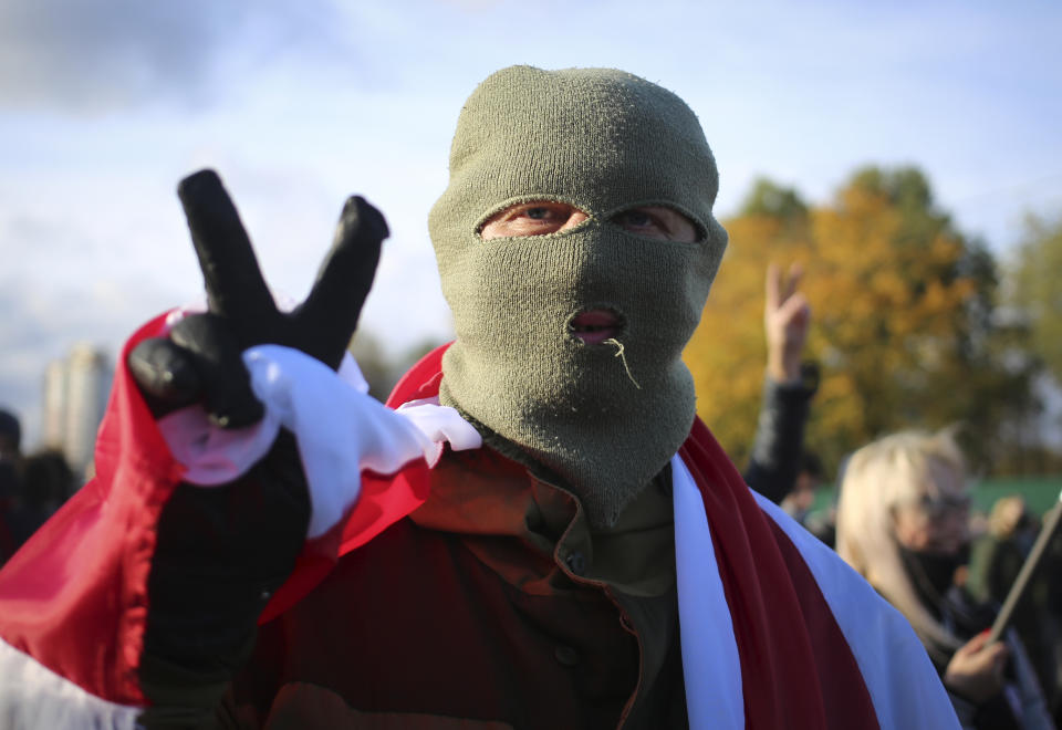 A masked protester gestures during an opposition rally to protest the official presidential election results in Minsk, Belarus, Sunday, Oct. 18, 2020. Tens of thousands rallied in Minsk once again on Sunday, demanding the resignation of the country's authoritarian leader. Mass weekend protests in the Belarusian capital have continued since Aug. 9, when officials handed President Alexander Lukashenko a landslide victory in an election widely seen as rigged. (AP Photo)