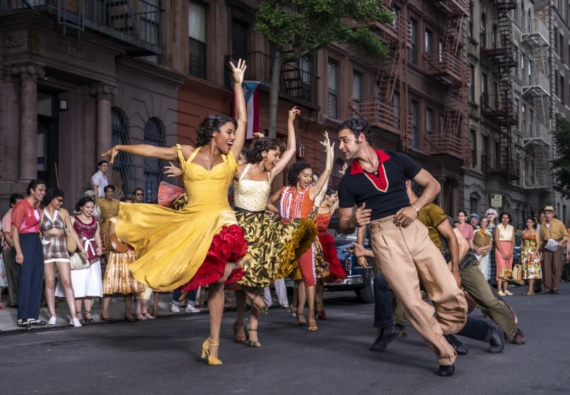 A group of people dancing on a street in colorful outfits