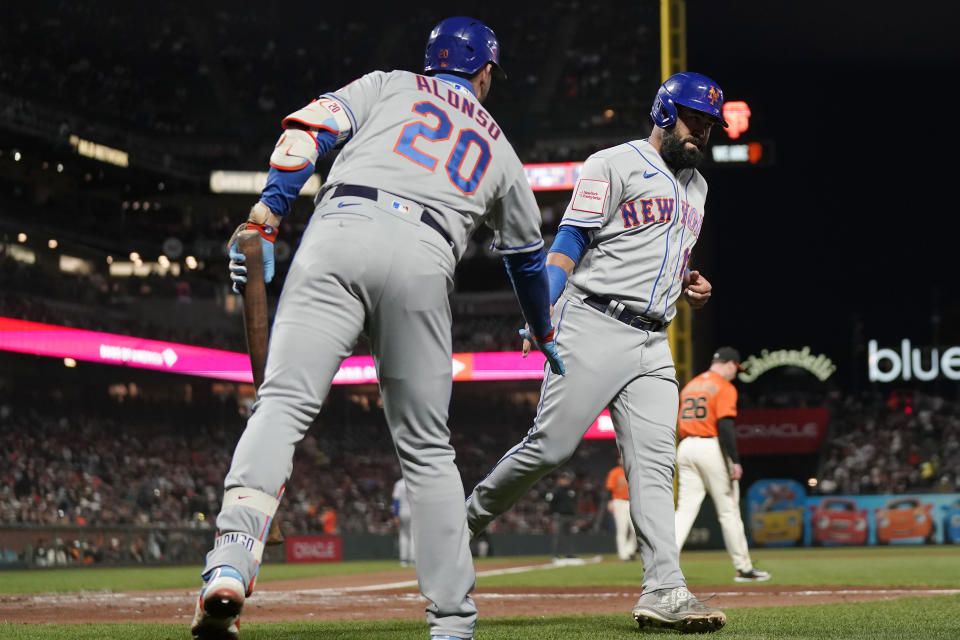 New York Mets' Luis Guillorme, right, is congratulated by Pete Alonso (20) after scoring against the San Francisco Giants during the fifth inning of a baseball game in San Francisco, Friday, April 21, 2023. (AP Photo/Jeff Chiu)