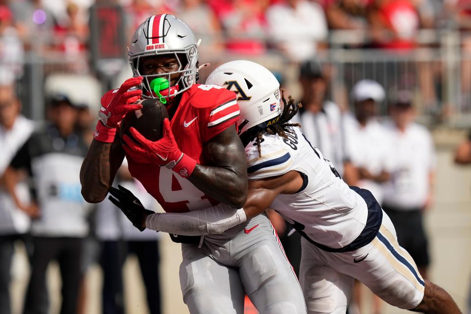 Aug 31, 2024; Columbus, OH, USA; Ohio State Buckeyes wide receiver Jeremiah Smith (4) catches his second touchdown pass of the first half in front of Akron Zips cornerback Devonte Golden-Nelson (3) during the NCAA football game at Ohio Stadium.