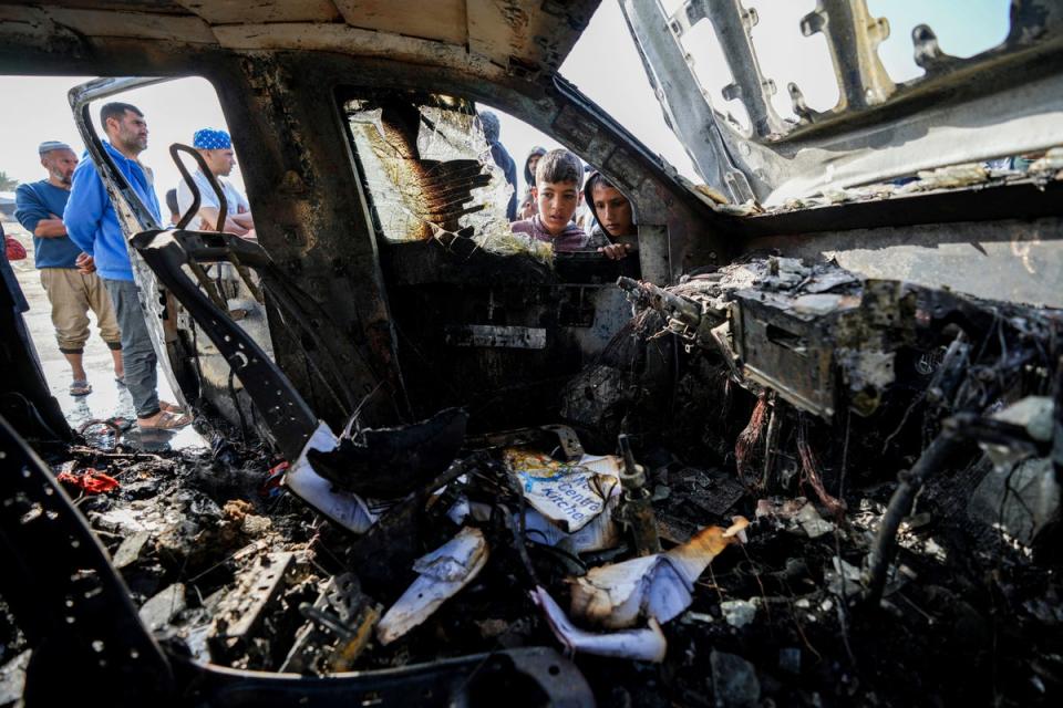 People inspect the site where World Central Kitchen workers were killed in Deir al-Balah in April (AP)