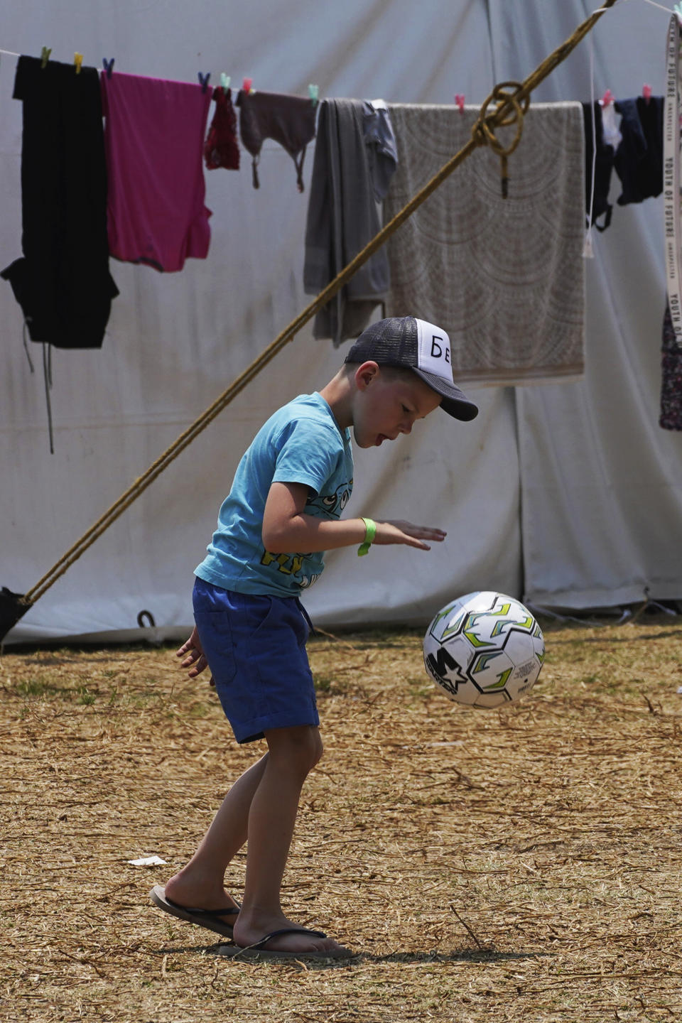 A Ukrainian refugee boy plays with a ball at a camp in Utopia Park, Iztapalapa, Mexico City, Monday, May 2, 2022. (AP Photo/Marco Ugarte)