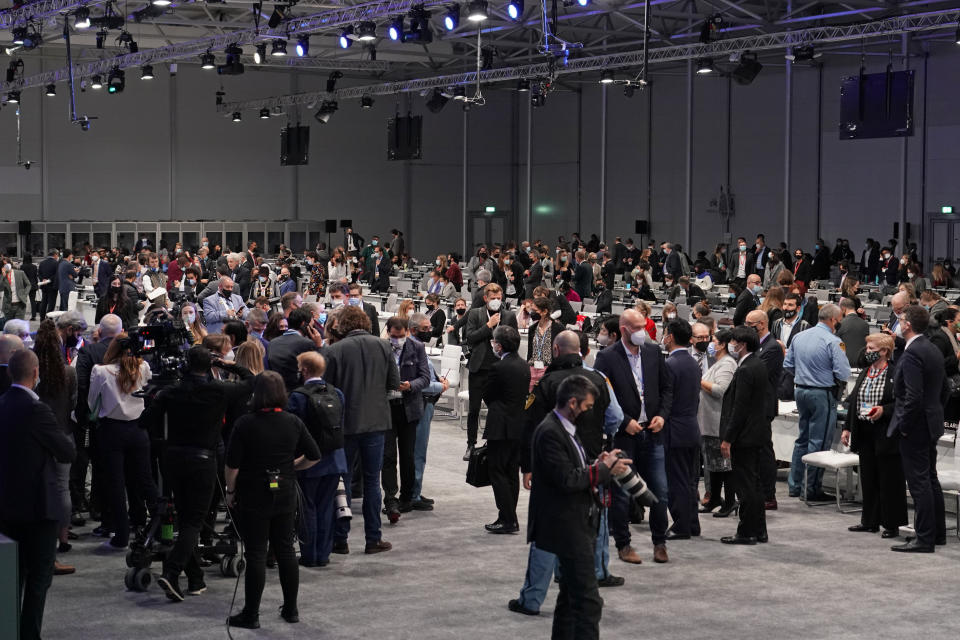 People gather during a stocktaking plenary session at the COP26 U.N. Climate Summit in Glasgow, Scotland, Saturday, Nov. 13, 2021. Going into overtime, negotiators at U.N. climate talks in Glasgow are still trying to find common ground on phasing out coal, when nations need to update their emission-cutting pledges and, especially, on money. (AP Photo/Alberto Pezzali)