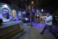 Chairs are thrown at a police van in Barcelona, Spain, Thursday, Oct. 17, 2019. Catalonia's separatist leader vowed Thursday to hold a new vote to secede from Spain in less than two years as the embattled northeastern region grapples with a wave of violence that has tarnished a movement proud of its peaceful activism. (AP Photo/Manu Fernandez)