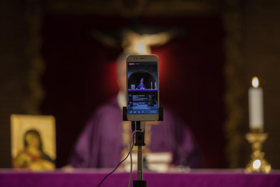 Catholic priest Catholic priest Jesus Higueras from the Santa Maria de Cana parish is seen on a smartphone during a live video streamed mass in Pozuelo de Alarcon, outskirts Madrid, Spain, Sunday, March 15, 2020. Pope Francis has praised people for their continuing efforts to help vulnerable communities, including the poor and the homeless, amid the coronavirus pandemic. The vast majority of people recover from the COVID-19. According to the World Health Organization, most people recover in about two to six weeks, depending on the severity of the illness. (AP Photo/Bernat Armangue)