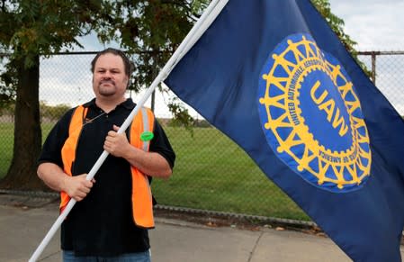 United Auto Worker, Aramark worker Mike Mucci, carries a UAW flag while picketing outside the General Motors Detroit-Hamtramck assembly plant in Detroit,