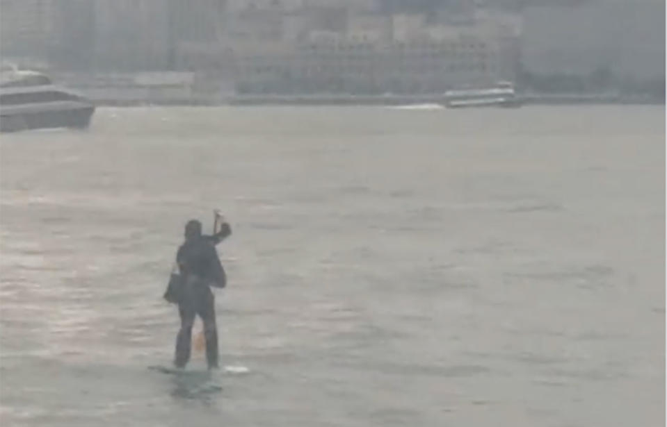 A man dressed in a suit was caught paddleboarding across the river. Source: Eunice Rivers via Stortyful