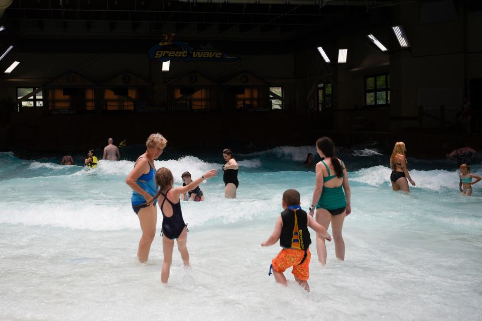 Families play in the wave pool.