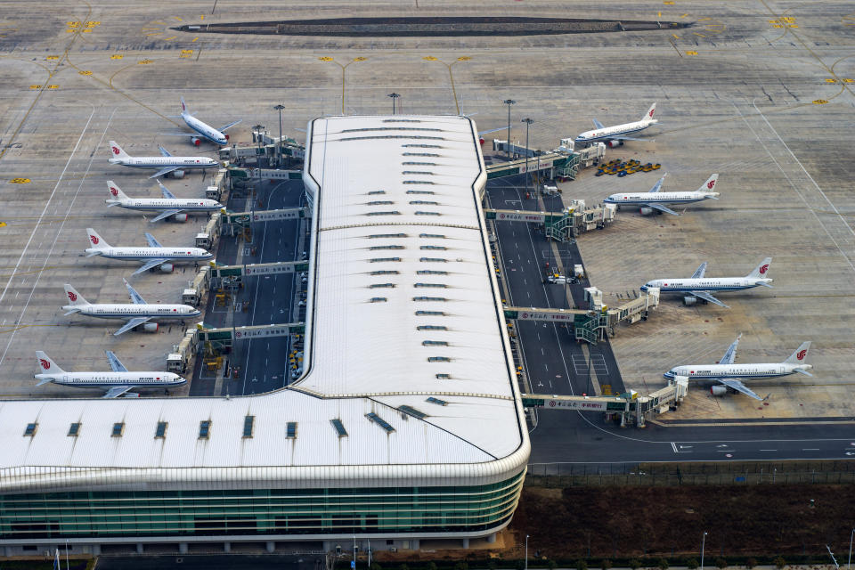 In this Jan. 28, 2020, photo, Air China planes are parked at gates of Wuhan Tianhe International Airport in Wuhan in central China's Hubei Province. British Airways halted all flights to China and American Airlines suspended Los Angeles flights to and from Shanghai and Beijing as efforts to contain a new virus intensifies. (Chinatopix via AP)