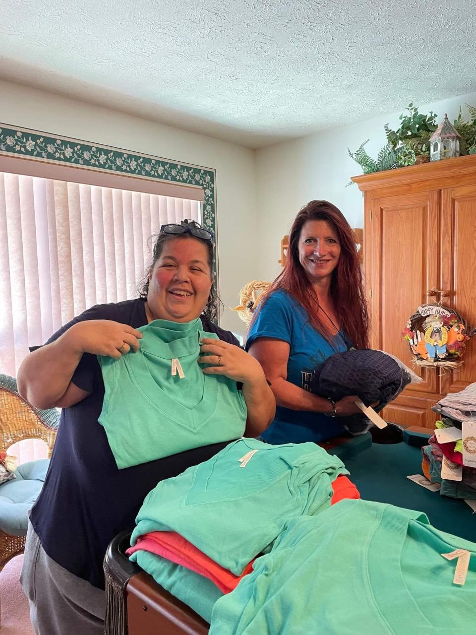 Cindy LaRosa and Colleen Fuhs prepare clothing donations for charity.