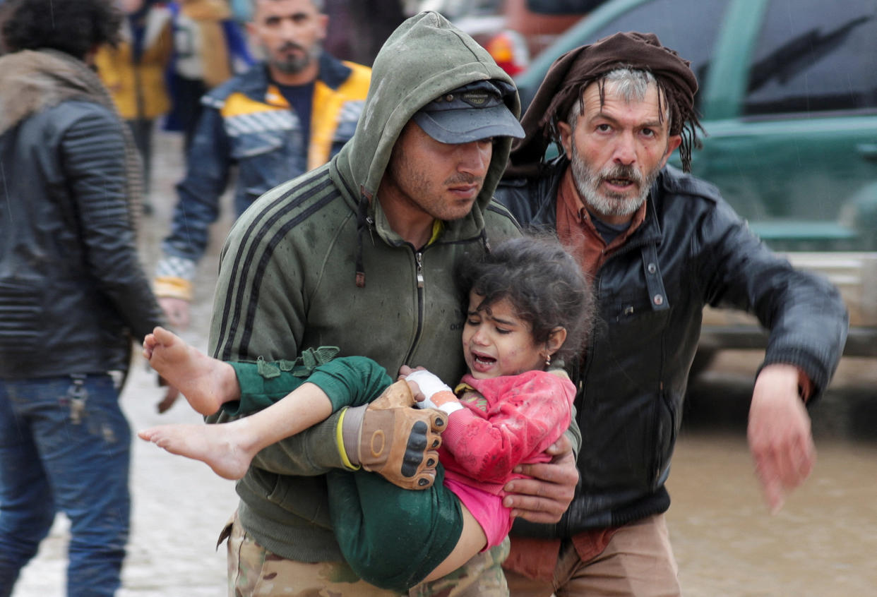 A man carries a girl following an earthquake in Jandaris, Syria. 