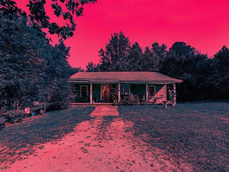 the byeres house from stranger things, photographed and lit in magenta and red