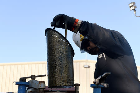 Carlos Riojas checks a filter at a wastewater injection facility operated by On Point Energy in Big Spring, Texas U.S. February 12, 2019. Picture taken February 12, 2019. REUTERS/Nick Oxford