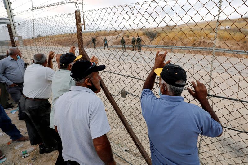 FILE PHOTO: Palestinian laborers gather near an Israeli checkpoint closed amid fears of a second wave of COVID-19 infections, near Hebron