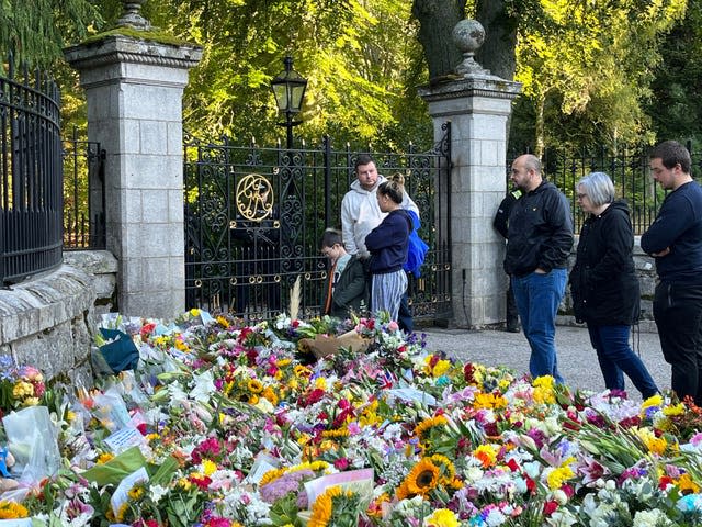 Flowers are laid at Balmoral in Scotland on Saturday following the death of the Queen 