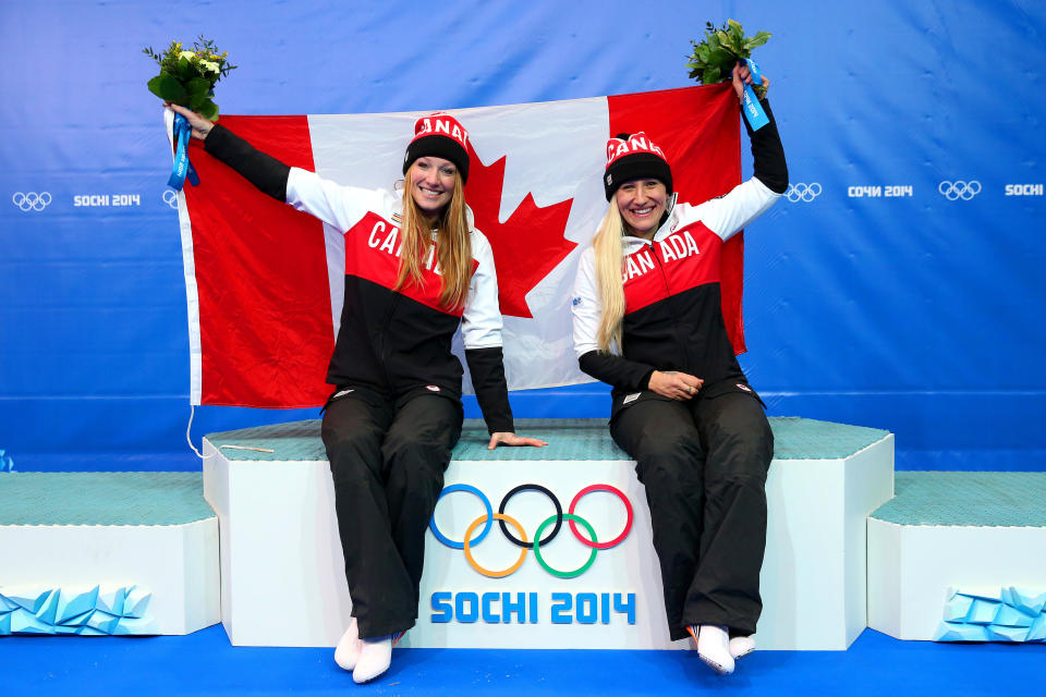 SOCHI, RUSSIA - FEBRUARY 19:  Kaillie Humphries and Heather Moyse (L) of Canada team 1 celebrate during the flower ceremony after winning the gold medal during the Women's Bobsleigh on Day 12 of the Sochi 2014 Winter Olympics at Sliding Center Sanki on February 19, 2014 in Sochi, Russia.  (Photo by Alex Livesey/Getty Images)