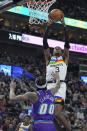 Minnesota Timberwolves forward Jaden McDaniels (3) goes to the basket as Utah Jazz guard Jordan Clarkson (00) defends during the first half of an NBA basketball game Wednesday, Feb. 8, 2023, in Salt Lake City. (AP Photo/Rick Bowmer)