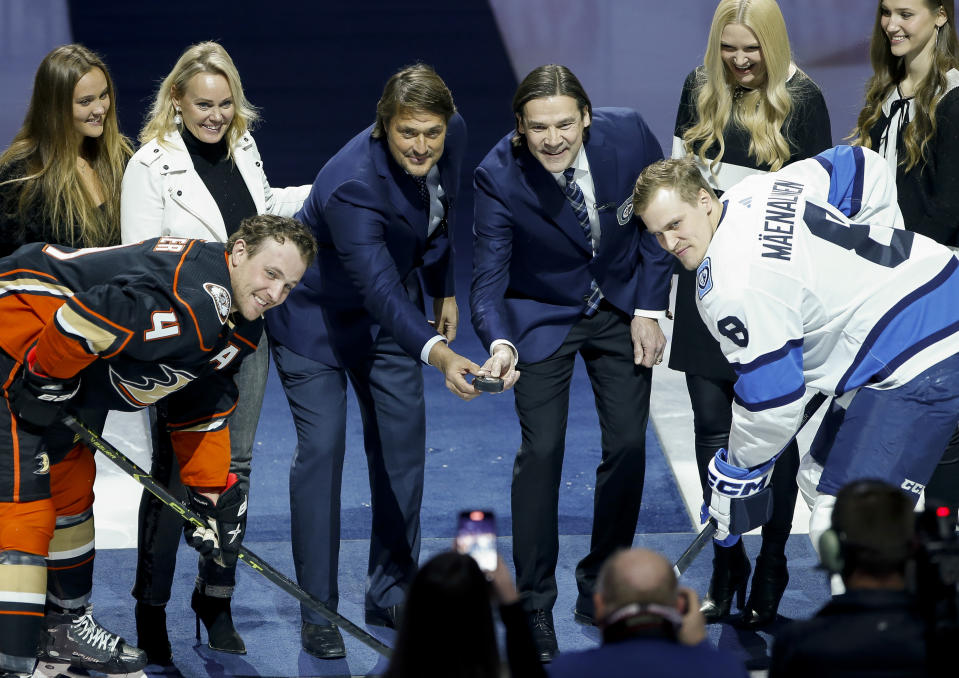 Former Winnipeg Jets' Teppo Numminen, center right, and Teemu Selanne, center left, prepare to drop the puck during a ceremony where they were inducted into the Winnipeg Jets Hall of Fame prior to an NHL game against the Anaheim Ducks in Winnipeg, Manitoba, Thursday, Nov. 17, 2022. (John Woods/The Canadian Press via AP)