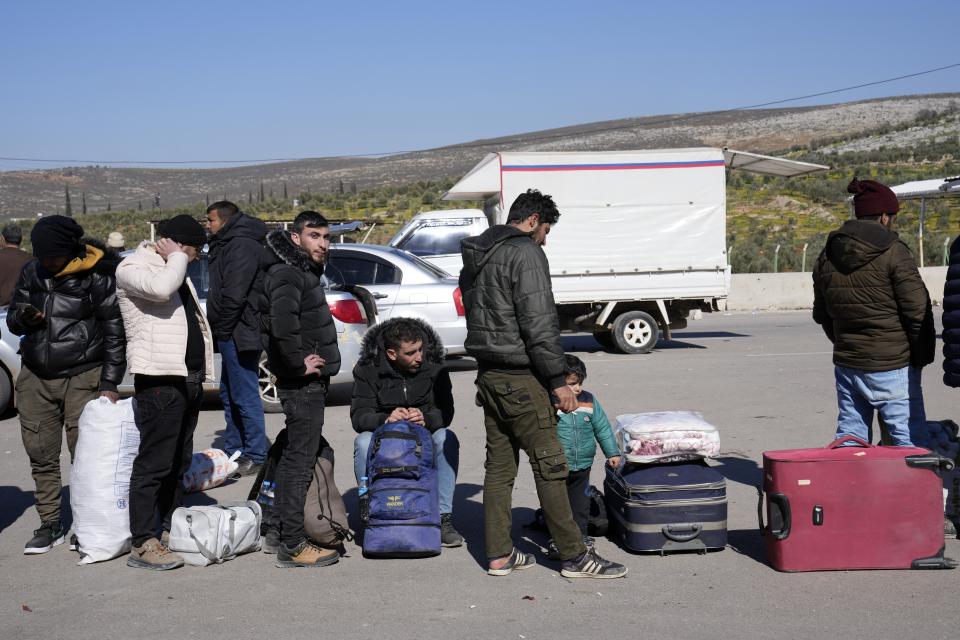 Syrians stand in a queue as they wait to return to their country from the Turkish crossing point of Cilvegozu, in Reyhanli, southeastern Turkey, Thursday, Feb. 9, 2023. Rescuers pulled more survivors from beneath the rubble of collapsed buildings Thursday, but hopes were starting to fade of finding many more people alive more than three days after a catastrophic earthquake and series of aftershocks hit Turkey and Syria. (AP Photo/Hussein Malla)